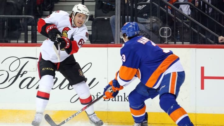 Mar 23, 2016; Brooklyn, NY, USA; Ottawa Senators left wing Mike Hoffman (68) passes the puck past New York Islanders defenseman Travis Hamonic (3) during the first period at Barclays Center. Mandatory Credit: Brad Penner-USA TODAY Sports