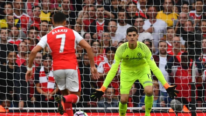 Arsenal's Chilean striker Alexis Sanchez (L) runs in to score the opening goal past Chelsea's Belgian goalkeeper Thibaut Courtois (R) during the English Premier League football match between Arsenal and Chelsea at the Emirates Stadium in London on September 24, 2016. / AFP / Ben STANSALL / RESTRICTED TO EDITORIAL USE. No use with unauthorized audio, video, data, fixture lists, club/league logos or 'live' services. Online in-match use limited to 75 images, no video emulation. No use in betting, games or single club/league/player publications. / (Photo credit should read BEN STANSALL/AFP/Getty Images)