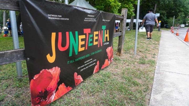 A banner hangs at a Juneteenth celebration at Eastwoods Park on Monday, June 19, 2023 in Austin. The event was held in Eastwoods Park, formerly called Wheeler’s Grove, in the neighborhood where one of the first Juneteenth celebrations was held in Austin over 150 years ago.