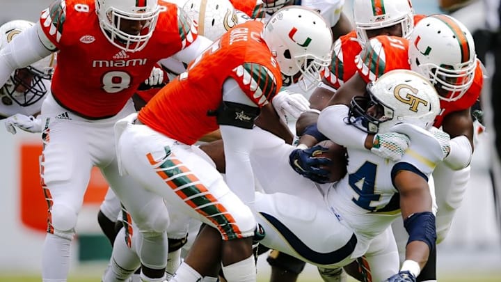 Nov 21, 2015; Miami Gardens, FL, USA; Georgia Tech Yellow Jackets running back Marcus Allen (center) is tackled by Miami Hurricanes linebacker Jermaine Grace (left) and linebacker Juwon Young (right) during the first half at Sun Life Stadium. Mandatory Credit: Steve Mitchell-USA TODAY Sports