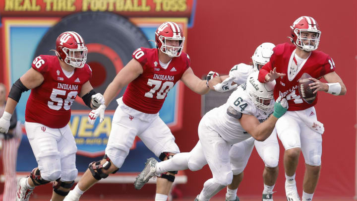 BLOOMINGTON, IN – OCTOBER 16: Jack Tuttle #14 of the Indiana Hoosiers is nearly sacked by Jacob Slade #64 of the Michigan State Spartans during the second half at Memorial Stadium on October 16, 2021 in Bloomington, Indiana. (Photo by Michael Hickey/Getty Images)