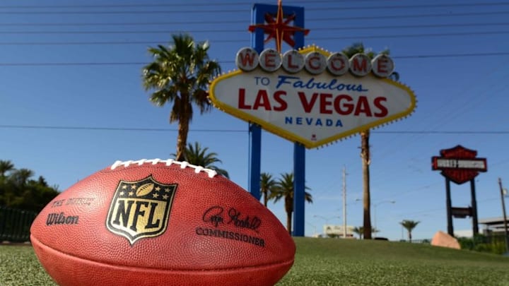 May 11, 2016; Las Vegas, NV, USA; General view of NFL Wilson Duke football at the "Welcome to Fabulous Las Vegas" sign on the Las Vegas strip on Las Vegas Blvd. Oakland Raiders owner Mark Davis (not pictured) has pledged $500 million toward building a 65,000-seat domed stadium in Las Vegas at a total cost of $1.4 billion. NFL commissioner Roger Goodell (not pictured) said Davis can explore his options in Las Vegas but would require 24 of 32 owners to approve the move. Mandatory Credit: Kirby Lee-USA TODAY Sports
