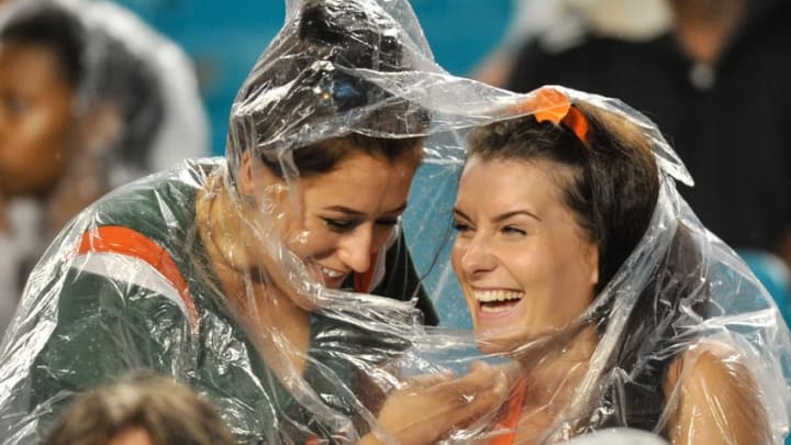 Sep 5, 2015; Miami Gardens, FL, USA; Miami Hurricanes fans share a raincoat during the second half of a game against Bethune Cookman Wildcats at Sun Life Stadium. Mandatory Credit: Steve Mitchell-USA TODAY Sports