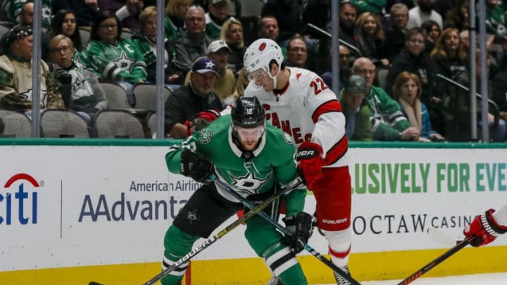DALLAS, TX - FEBRUARY 11: Dallas Stars center Radek Faksa (12) and Carolina Hurricanes defenseman Brett Pesce (22) battle for the puck during the game between the Dallas Stars and the Carolina Hurricanes on February 11, 2019 at American Airlines Center in Dallas, Texas. (Photo by Matthew Pearce/Icon Sportswire via Getty Images)