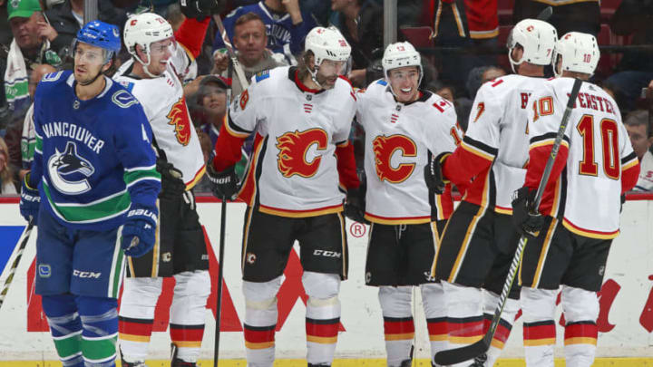 VANCOUVER, BC - OCTOBER 14: Michael Del Zotto #4 of the Vancouver Canucks looks on as Johnny Gaudreau #13 of the Calgary Flames is congratulated after scoring during their NHL game at Rogers Arena October 14, 2017 in Vancouver, British Columbia, Canada. (Photo by Jeff Vinnick/NHLI via Getty Images)