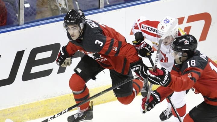 VICTORIA , BC - DECEMBER 19: Josh Brook #3 and Markus Phillips #18 of Team Canada battle with Ian Derungs #27 of Team Switzerland at the IIHF World Junior Championships at the Save-on-Foods Memorial Centre on December 19, 2018 in Victoria, British Columbia, Canada. Canada defeated Switzerland 5-3. (Photo by Kevin Light/Getty Images)"n"n"n"n