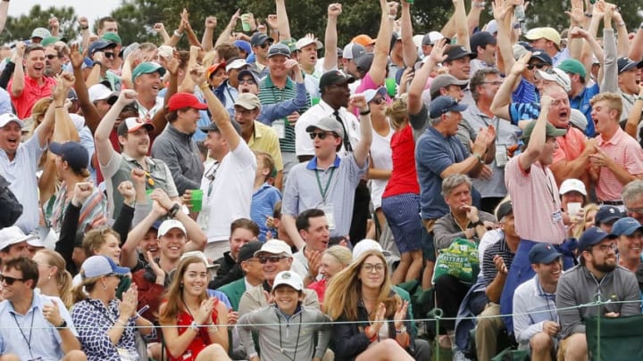 AUGUSTA, GEORGIA - APRIL 14: Patrons cheer on the 18th green after Tiger Woods of the United States score is updated on the leaderboard during the final round of the Masters at Augusta National Golf Club on April 14, 2019 in Augusta, Georgia. (Photo by Kevin C. Cox/Getty Images)
