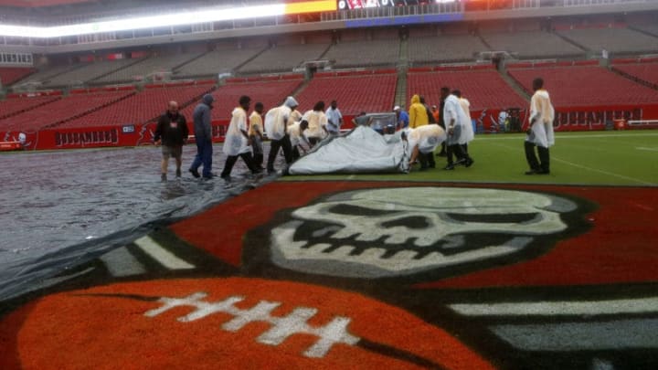 TAMPA, FL - AUGUST 31: Members of the Tampa Bay Buccaneers' grounds crew remove a large tarp off of the playing field as heavy rains associated with Tropical Storm Hermine impact the Tampa Bay area prior to the start of and the Washington Redskins on August 31, 2016 at Raymond James Stadium in Tampa, Florida. (Photo by Brian Blanco/Getty Images)