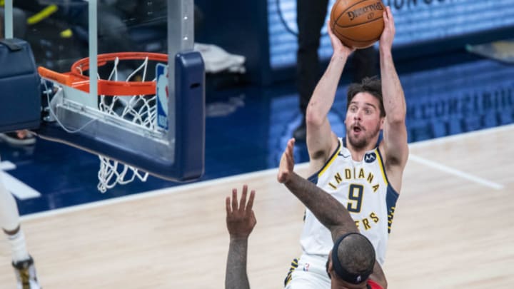 Jan 6, 2021; Indianapolis, Indiana, USA; Indiana Pacers guard T.J. McConnell (9) shoots the ball over Houston Rockets center DeMarcus Cousins (15) in the second quarter at Bankers Life Fieldhouse. Mandatory Credit: Trevor Ruszkowski-USA TODAY Sports