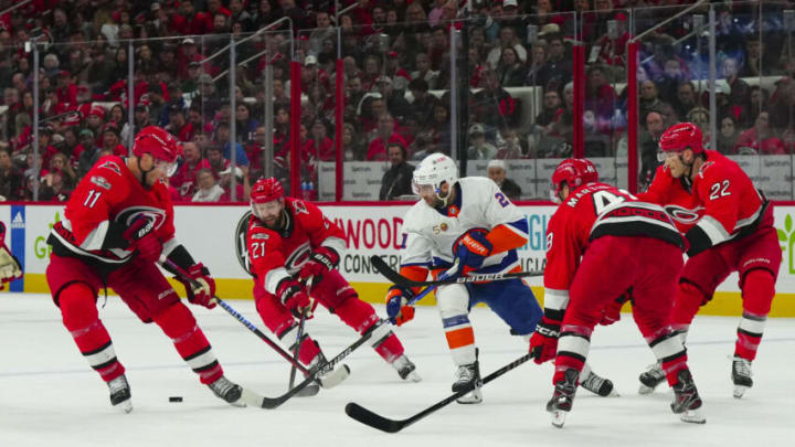 Apr 19, 2023; Raleigh, North Carolina, USA; New York Islanders center Kyle Palmieri (21) tries to control the puck past defenseman Brett Pesce (22) left wing Jordan Martinook (48) center Derek Stepan (21) and center Jordan Staal (11) during the second period in game two of the first round of the 2023 Stanley Cup Playoffs at PNC Arena. Mandatory Credit: James Guillory-USA TODAY Sports