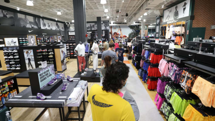 GARDEN CITY, NEW YORK - JULY 10: Customers wait in line to pay for items at Dick's Sporting Goods store at Roosevelt Field Mall which reopened today on July 10, 2020 in Garden City, New York. Malls across the state were ordered to close March 19, and other businesses deemed nonessential were ordered to close the same week, to help stop the spread of the coronavirus. The openings follow Gov. Andrew M. Cuomo’s announcement Wednesday that malls outside of New York City can open if they have high-efficiency air filtration systems to help control the spread of the virus. (Photo by Al Bello/Getty Images)