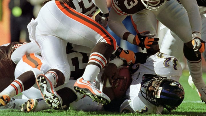 Baltimore Ravens running back Erricht Rhett (32) scores the Ravens first touchdown as Cleveland Browns players Daylon McCutcheon (33) and Corey Fuller attempt to stop him in the first quarter 07 November 1999 at Cleveland Browns Stadium in Cleveland, Ohio. The Ravens defeated the Browns 41-9. AFP photo/David MAXWELL (Photo by DAVID MAXWELL / AFP) (Photo by DAVID MAXWELL/AFP via Getty Images)