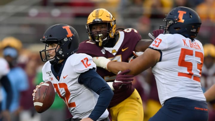 MINNEAPOLIS, MINNESOTA – OCTOBER 05: Quarterback Matt Robinson #12 of the Illinois Fighting Illini carries the ball as teammate Kendrick Green #53 blocks Esezi Otomewo #9 of the Minnesota Gophers during the third quarter of the game at TCF Bank Stadium on October 5, 2019 in Minneapolis, Minnesota. The Gophers defeated the Fighting Illini 40-17. (Photo by Hannah Foslien/Getty Images)