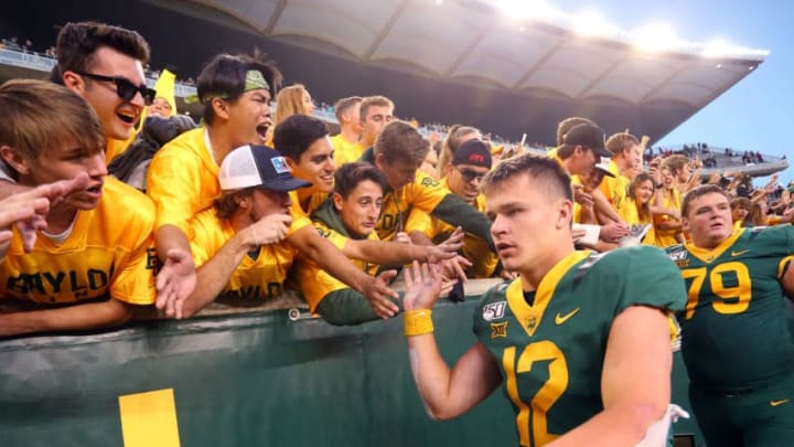 WACO, TEXAS - OCTOBER 12: Quarteback Charlie Brewer #12 of the Baylor Bears high fives fans after the overtime win against the Texas Tech Red Raiderson October 12, 2019 in Waco, Texas. (Photo by Richard Rodriguez/Getty Images)