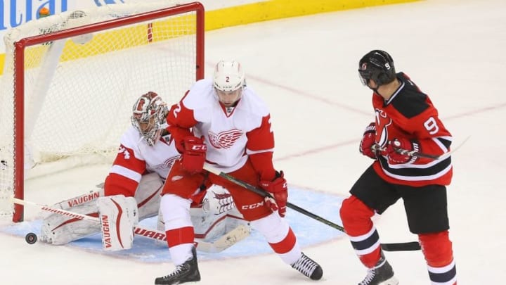 Jan 4, 2016; Newark, NJ, USA; Detroit Red Wings goalie Petr Mrazek (34) makes a save while Detroit Red Wings defenseman Brendan Smith (2) and New Jersey Devils left wing Jiri Tlusty (9) look for the rebound during the third period at Prudential Center. The Red Wings defeated the Devils 1-0. Mandatory Credit: Ed Mulholland-USA TODAY Sports