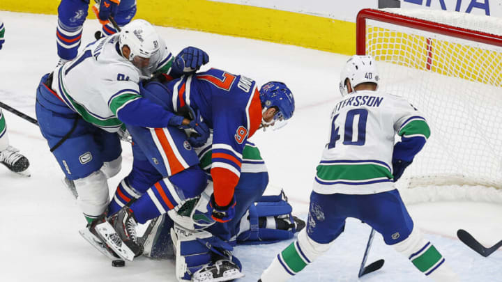 Oct 14, 2023; Edmonton, Alberta, CAN; Vancouver Canucks forward Dakota Joshua (81) knocks Edmonton Oilers forward Connor McDavid (97) into Vancouver Canucks goaltender Casey DeSmith (29) during the third period at Rogers Place. Mandatory Credit: Perry Nelson-USA TODAY Sports
