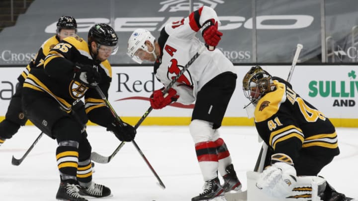 Mar 28, 2021; Boston, Massachusetts, USA; Boston Bruins defenseman Jeremy Lauzon (55) battles New Jersey Devils center Travis Zajac (19) for the puck in front of goaltender Jaroslav Halak (41) during the second period at TD Garden. Mandatory Credit: Winslow Townson-USA TODAY Sports