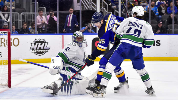 Mar 28, 2022; St. Louis, Missouri, USA; Vancouver Canucks goaltender Jaroslav Halak (41) and defenseman Quinn Hughes (43) defend against St. Louis Blues right wing Alexei Toropchenko (65) during the second period at Enterprise Center. Mandatory Credit: Jeff Curry-USA TODAY Sports