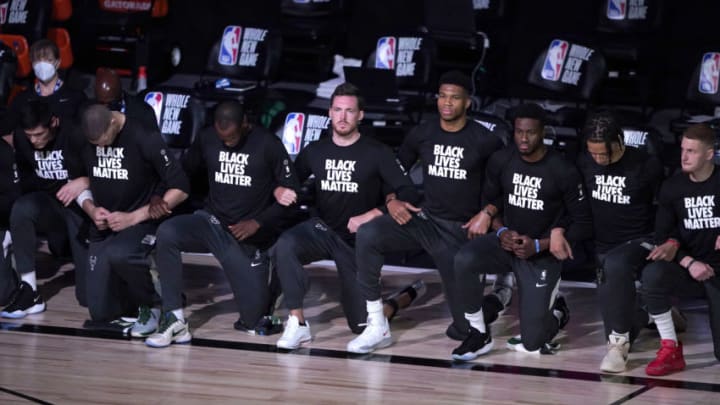LAKE BUENA VISTA, FL - JULY 31: Players kneel and wear Black Lives Matter shirts before the start of an NBA basketball game between the Milwaukee Bucks and the Boston Celtics Friday, July 31, 2020, in Lake Buena Vista, Florida. NOTE TO USER: User expressly acknowledges and agrees that, by downloading and or using this photograph, User is consenting to the terms and conditions of the Getty Images License Agreement. (Photo by Ashley Landis-Pool/Getty Images)