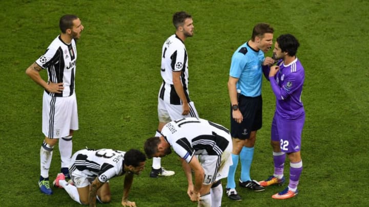 German referee Felix Brych (2nd-R) talks to Real Madrid's Spanish midfielder Isco after he committed a foul on Juventus' Brazilian defender Dani Alves (2nd-L) during the UEFA Champions League final football match between Juventus and Real Madrid at The Principality Stadium in Cardiff, south Wales, on June 3, 2017. / AFP PHOTO / Ben STANSALL (Photo credit should read BEN STANSALL/AFP via Getty Images)