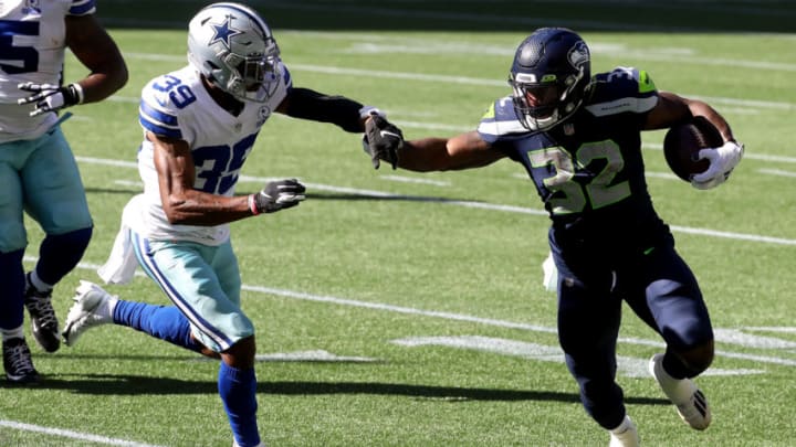 SEATTLE, WASHINGTON - SEPTEMBER 27: Chris Carson #32 of the Seattle Seahawks runs with the ball against Brandon Carr #39 of the Dallas Cowboys during the second quarter in the game at CenturyLink Field on September 27, 2020 in Seattle, Washington. (Photo by Abbie Parr/Getty Images)