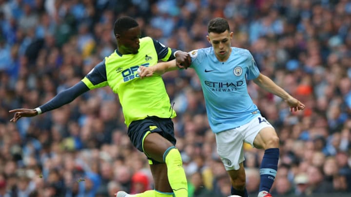 MANCHESTER, ENGLAND - AUGUST 19: Phil Foden of Manchester City is challenged by Adama Diakhaby of Huddersfield Town during the Premier League match between Manchester City and Huddersfield Town at Etihad Stadium on August 19, 2018 in Manchester, United Kingdom. (Photo by Alex Livesey/Getty Images)