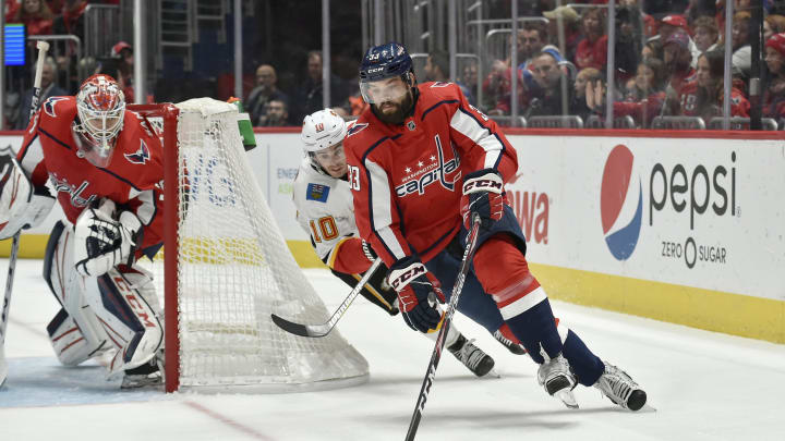 WASHINGTON, DC - NOVEMBER 03: Capitals defenseman Radko Gudas (33) skates the puck from behind his own net as goalie Ilya Samsonov (30) watches during the Calgary Flames vs. Washington Capitals on November 3, 2019 at Capital One Arena in Washington, D.C.. (Photo by Randy Litzinger/Icon Sportswire via Getty Images)