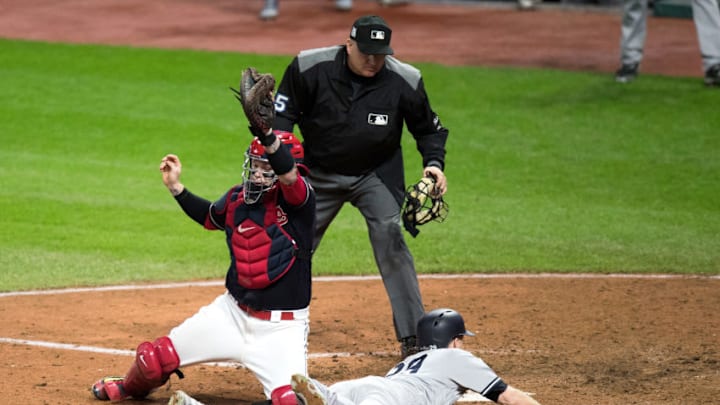CLEVELAND, OH - OCTOBER 11: New York Yankees third baseman Todd Frazier (29) slides safely into home plate ahead of the tag of Cleveland Indians catcher Roberto Perez (55) as home plate umpire Jeff Nelson (45) looks on during the ninth inning of the 2017 American League Divisional Series Game 5 between the New York Yankees and Cleveland Indians on October 11, 2017, at Progressive Field in Cleveland, OH. New York defeated Cleveland 5-2 to advance to the 2017 American League Championship series. (Photo by Frank Jansky/Icon Sportswire via Getty Images)