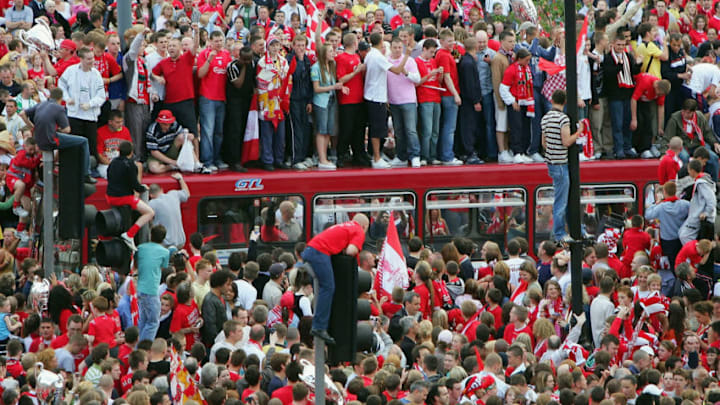 LIVERPOOL, ENGLAND - MAY 26: Liverpool fans climb on top of a bus which became stuck in traffic as they wait for their team to arrive at St. George's Hall during the Liverpool Champions League Victory Parade on May 26, 2005 in Liverpool, England. Over 250,000 cheering fans have lined the roads to celebrate after Liverpool defeated AC Milan in a penalty shoot out 3-2 to win the UEFA Champions League Final. (Photo by Scott Barbour/Getty Images)