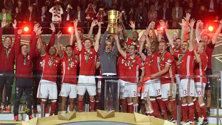 Bayern Munich's players and Bayern Munich's Spanish head coach Pep Guardiola (C) celebrate with the trophy after defeating Dortmund in the penalty shootout of the German Cup (DFB Pokal) final football match Bayern Munich vs Borussia Dortmund at the Olympic stadium in Berlin on May 21, 2016.Bayern Munich won the German Cup. / AFP / CHRISTOF STACHE / RESTRICTIONS: ACCORDING TO DFB RULES IMAGE SEQUENCES TO SIMULATE VIDEO IS NOT ALLOWED DURING MATCH TIME. MOBILE (MMS) USE IS NOT ALLOWED DURING AND FOR FURTHER TWO HOURS AFTER THE MATCH. == RESTRICTED TO EDITORIAL USE == FOR MORE INFORMATION CONTACT DFB DIRECTLY AT 49 69 67880 / (Photo credit should read CHRISTOF STACHE/AFP/Getty Images)