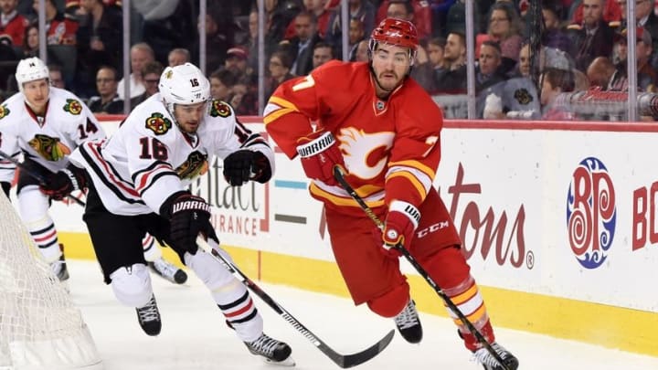 Nov 18, 2016; Calgary, Alberta, CAN; Calgary Flames defenseman TJ Brodie (7) clears the puck away from Chicago Blackhawks center Marcus Kruger (16) during the second period at Scotiabank Saddledome. Mandatory Credit: Candice Ward-USA TODAY Sports