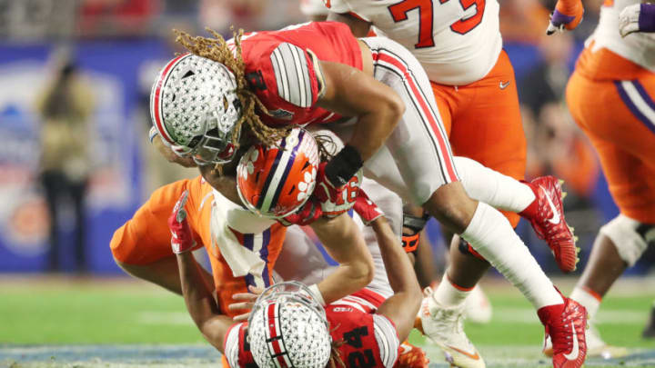 GLENDALE, ARIZONA - DECEMBER 28: Trevor Lawrence #16 of the Clemson Tigers is hit by Shaun Wade #24 and Chase Young #2 of the Ohio State Buckeyes in the first half during the College Football Playoff Semifinal at the PlayStation Fiesta Bowl at State Farm Stadium on December 28, 2019 in Glendale, Arizona. (Photo by Christian Petersen/Getty Images)