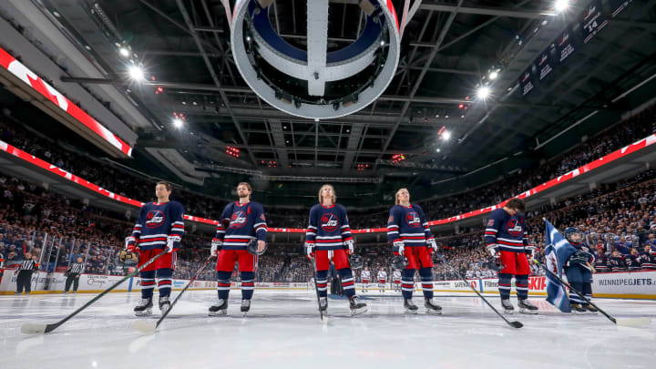 WINNIPEG, MB – FEBRUARY 11: Neal Pionk #4, Josh Morrissey #44, Kyle Connor #81, Patrik Laine #29 and Mark Scheifele #55 of the Winnipeg Jets stand on the ice during the singing of the National anthem prior to puck drop against the New York Rangers at the Bell MTS Place on February 11, 2020 in Winnipeg, Manitoba, Canada. (Photo by Jonathan Kozub/NHLI via Getty Images)