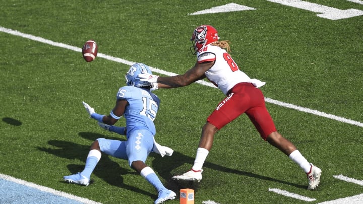 Oct 24, 2020; Chapel Hill, North Carolina, USA; North Carolina Tar Heels defensive back DeAndre Hollins (15) tries to intercept a pass intended for North Carolina State Wolfpack wide receiver Devin Carter (88) in the third quarter at Kenan Memorial Stadium. Mandatory Credit: Bob Donnan-USA TODAY Sports