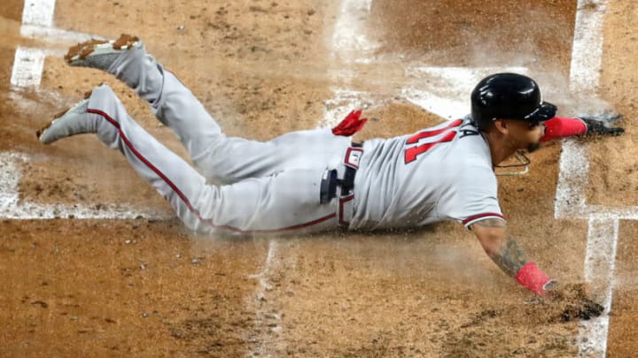MIAMI, FLORIDA - OCTOBER 04: Orlando Arcia #11 of the Atlanta Braves slides home against the Miami Marlins during the second inning of the game at loanDepot park on October 04, 2022 in Miami, Florida. (Photo by Megan Briggs/Getty Images)