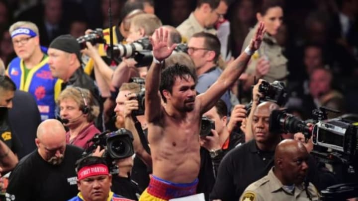 May 2, 2015; Las Vegas, NV, USA; Manny Pacquiao (yellow/red trunks) waves to the crowd after being defeated by Floyd Mayweather (not pictured) during their world welterweight championship bout at MGM in Garden Arena. Mayweather won via unanimous decision. Mandatory Credit: Joe Camporeale-USA TODAY Sports