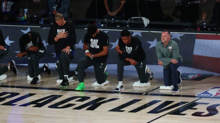 LAKE BUENA VISTA, FLORIDA - AUGUST 12: Head coach Michael Malone (R) of the Denver Nuggets kneels with his team during the playing of the national anthem before a game against the LA Clippers at AdventHealth Arena at ESPN Wide World Of Sports Complex on August 12, 2020 in Lake Buena Vista, Florida. NOTE TO USER: User expressly acknowledges and agrees that, by downloading and or using this photograph, User is consenting to the terms and conditions of the Getty Images License Agreement. (Photo by Kim Klement-Pool/Getty Images)