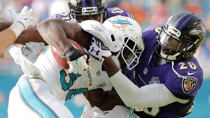 Dec 6, 2015; Miami Gardens, FL, USA; Miami Dolphins running back Damien Williams (34) is tackled by Baltimore Ravens free safety Brynden Trawick (28) during the second half at Sun Life Stadium. The Dolphins won 15-13. Mandatory Credit: Steve Mitchell-USA TODAY Sports