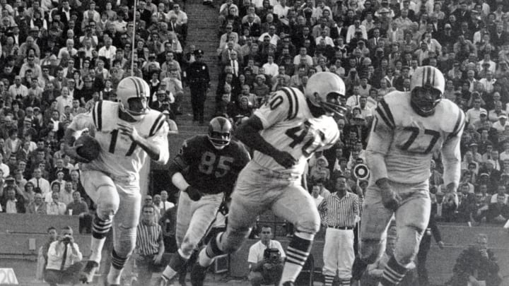 Nov 12, 1961; Los Angeles, CA, USA; FILE PHOTO; Los Angeles Rams kick returner Abe Woodson (40) and left guard Bruce Bosley (77) support running back Billy Kilmer (17) as he carries the ball against the San Francisco 49ers at Los Angeles Memorial Coliseum during the 1961 season. Mandatory Credit: David Boss-USA TODAY Sports