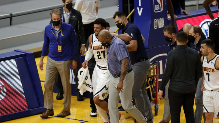 Jamal Murray of the Denver Nuggets is helped off the court (Photo by Ezra Shaw/Getty Images)