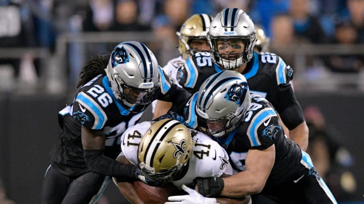 CHARLOTTE, NC – DECEMBER 17: Alvin Kamara #41 of the New Orleans Saints runs the ball against Luke Kuechly #59 and Donte Jackson #26 of the Carolina Panthers in the first quarter during their game at Bank of America Stadium on December 17, 2018 in Charlotte, North Carolina. (Photo by Grant Halverson/Getty Images)