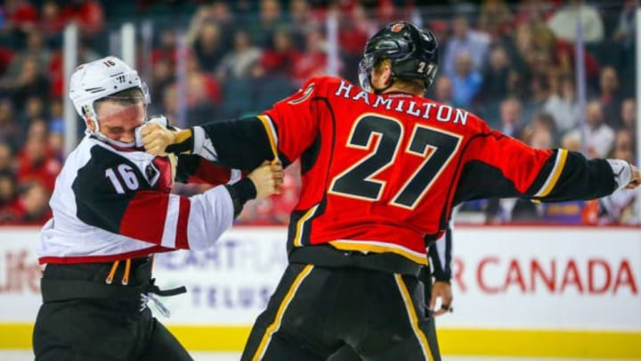 Oct 5, 2016; Calgary, Alberta, CAN; Arizona Coyotes left wing Max Domi (16) and Calgary Flames defenseman Dougie Hamilton (27) fight during the first period during a preseason hockey game at Scotiabank Saddledome. Mandatory Credit: Sergei Belski-USA TODAY Sports