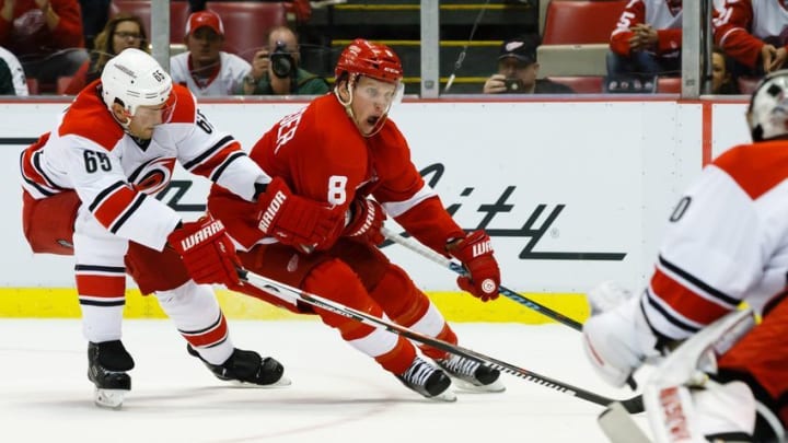 Oct 27, 2015; Detroit, MI, USA; Detroit Red Wings left wing Justin Abdelkader (8) skates with the puck on Carolina Hurricanes goalie Cam Ward (30) defended by Carolina Hurricanes defenseman Ron Hainsey (65) in the third period at Joe Louis Arena. Carolina won 3-1. Mandatory Credit: Rick Osentoski-USA TODAY Sports