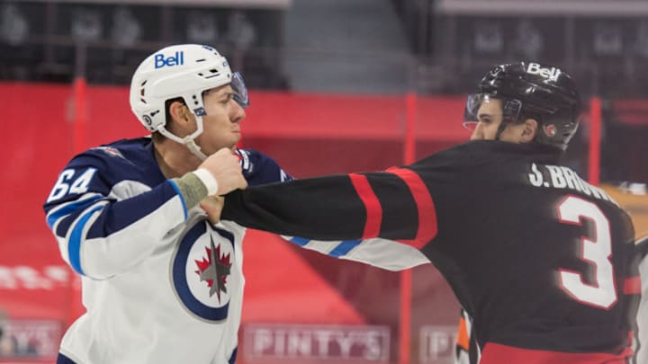 Apr 12, 2021; Ottawa, Ontario, CAN; Winnipeg Jets defenseman Logan Stanley (64) fights with Ottawa Senators defenseman Josh Brown (3) in the first period at the Canadian Tire Centre. Mandatory Credit: Marc DesRosiers-USA TODAY Sports