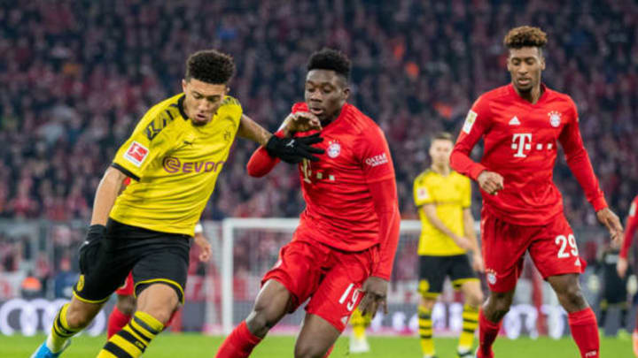 MUNICH, GERMANY – NOVEMBER 09: Jadon Sancho of Borussia Dortmund is challenged by Alphonso Davies of FC Bayern Muenchen and Kingsley Coman of FC Bayern Muenchen during the Bundesliga match between FC Bayern Muenchen and Borussia Dortmund at Allianz Arena on November 09, 2019 in Munich, Germany. (Photo by Boris Streubel/Getty Images)