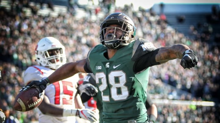 Nov 12, 2016; East Lansing, MI, USA; Michigan State Spartans running back Madre London (28) celebrates a touchdown run against the Rutgers Scarlet Knights during the second half of a game against the Rutgers Scarlet Knights at Spartan Stadium. Mandatory Credit: Mike Carter-USA TODAY Sports