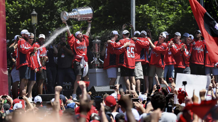 WASHINGTON, DC – JUNE 12:Washington Capitals right wing Tom Wilson (43) sprays the crowd with a beverage as Washington Capitals goaltender Philipp Grubauer (31) hoists the Stanley Cup after a parade on Tuesday, June 12, 2018, in honor of the team winning the NHL Stanley Cup.(Photo by Toni L. Sandys/The Washington Post via Getty Images)