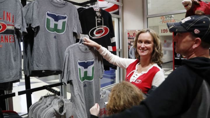Carolina Hurricanes fans Jennifer Miller, left, and her husband Lawrence Miller, right, and their daughter Avery Miller, 9, check out the Hartford Whalers shirts for sale at The Eye before the Hurricanes play host to the Montreal Canadiens at PNC Arena in Raleigh, N.C., on Thursday, Feb. 1, 2018. It's the first time items from the team's former identity are being sold, a change brought about by the Canes' new owner, Tom Dundon. (Chris Seward/Raleigh News & Observer/TNS via Getty Images)