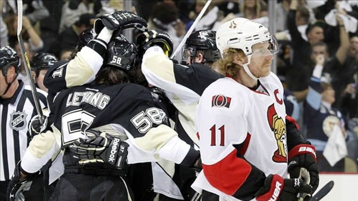 May 24, 2013; Pittsburgh, PA, USA; Ottawa Senators right wing Daniel Alfredsson (11) reacts as the Pittsburgh Penguins celebrate a goal by left wing James Neal (18) during the second period in game five of the second round of the 2013 Stanley Cup Playoffs at the CONSOL Energy Center. Mandatory Credit: Charles LeClaire-USA TODAY Sports