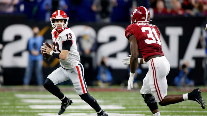 Georgia Bulldogs quarterback Stetson Bennett (13) scrambles with the ball as Alabama Crimson Tide linebacker Will Anderson Jr. (31) gives chase Monday, Jan. 10, 2022, during the College Football Playoff National Championship at Lucas Oil Stadium in Indianapolis.